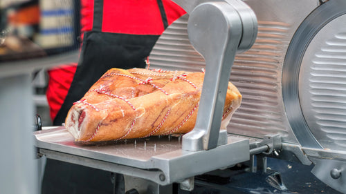Cutting meat on a commercial meat slicer