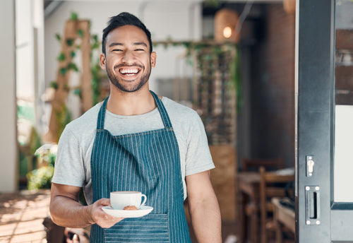 Cafe Owner smiling and serving a coffee